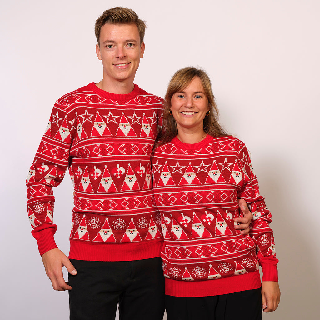 Un couple portant un pull de Noël rouge avec des lutins.